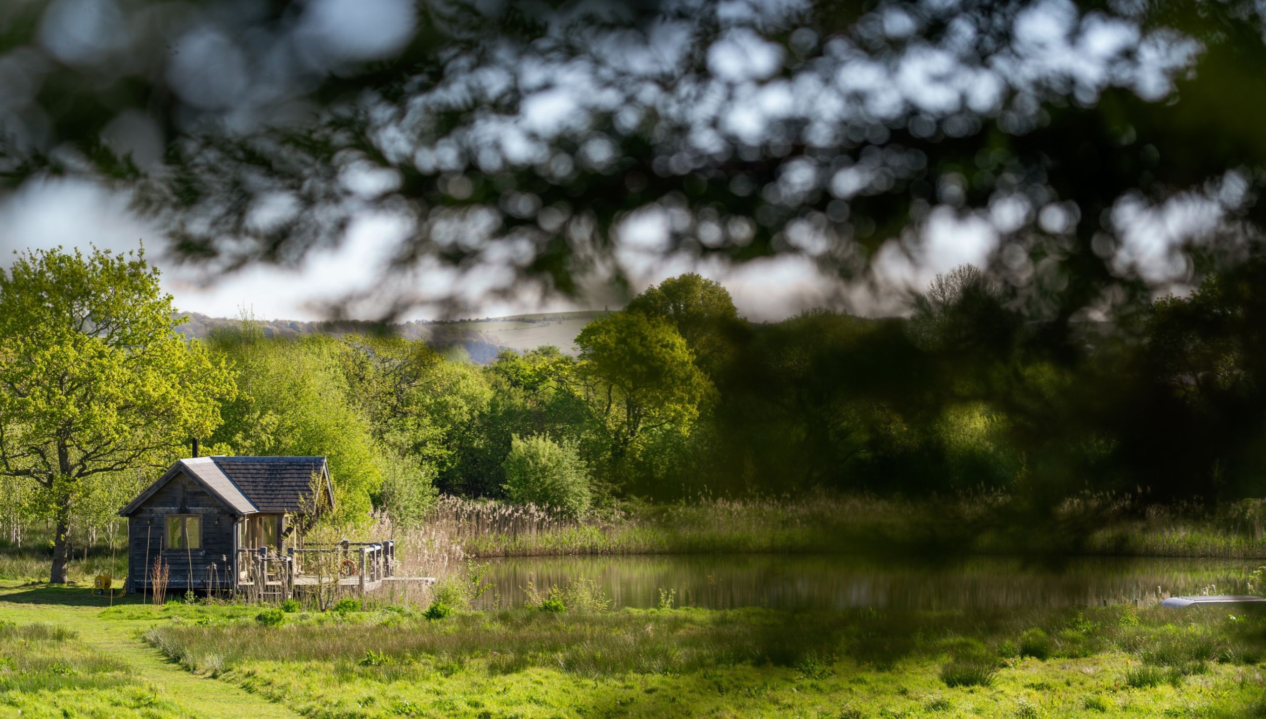 Oak frame boathouse in the distance, sitting on the lakeside