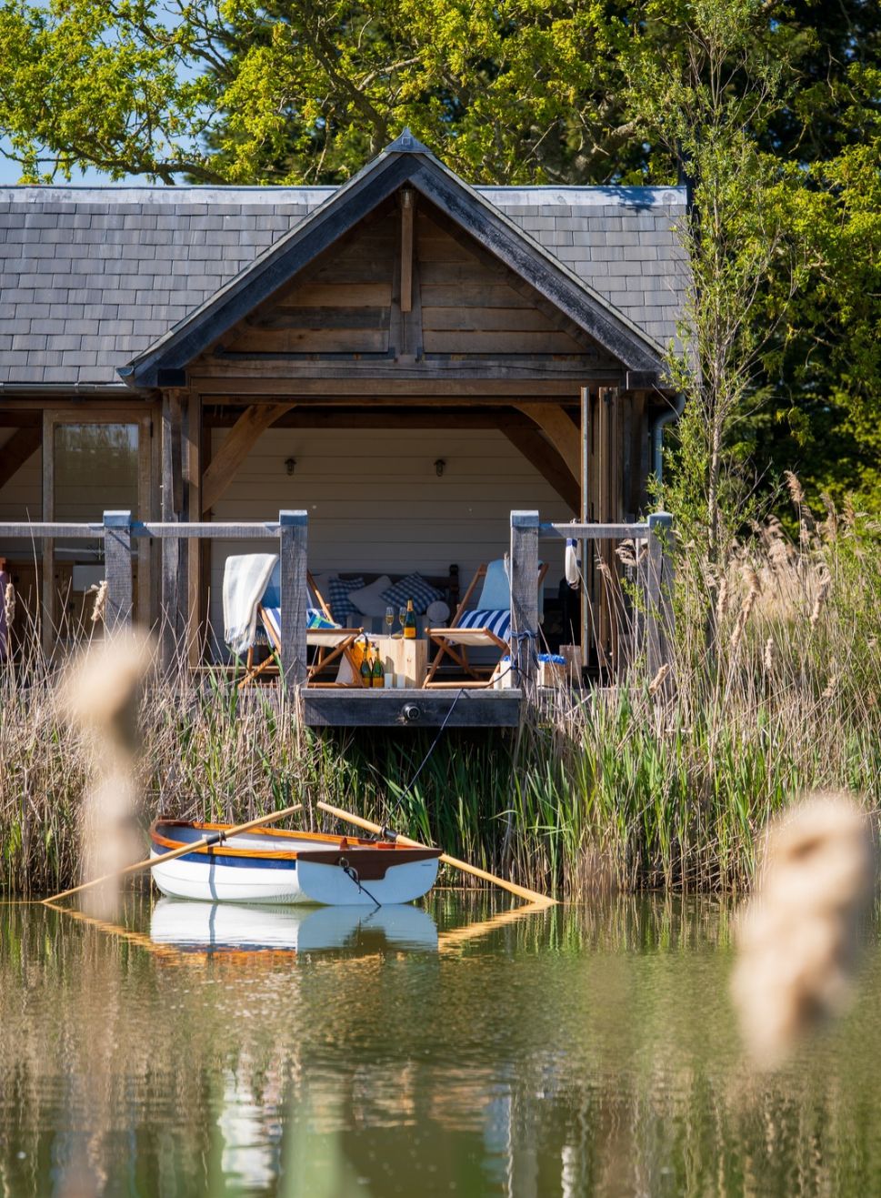 Oak framed boathouse exterior with deckchairs in front of the lake