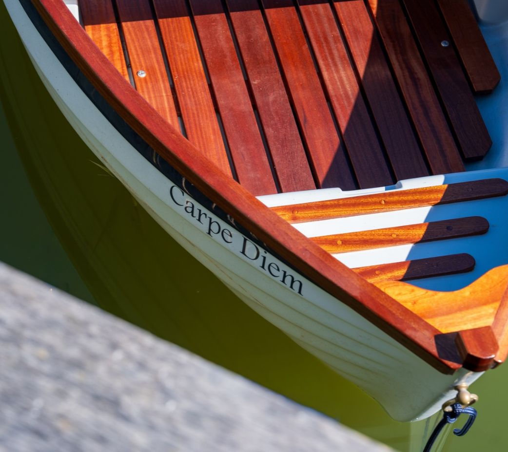 Carpe Diem boat in front of oak frame boathouse on the lake